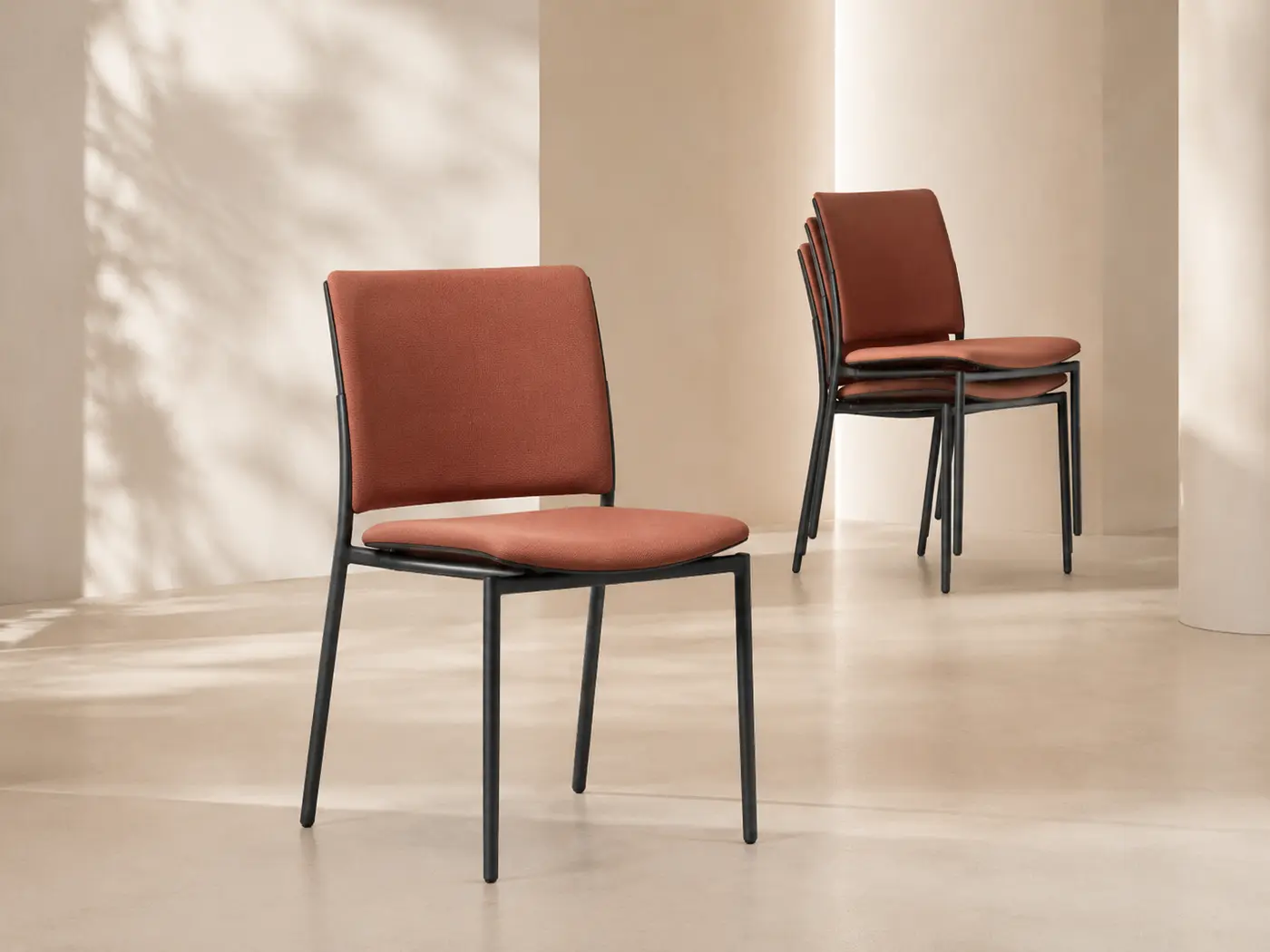 Stackable chair in muted terracotta upholstery
